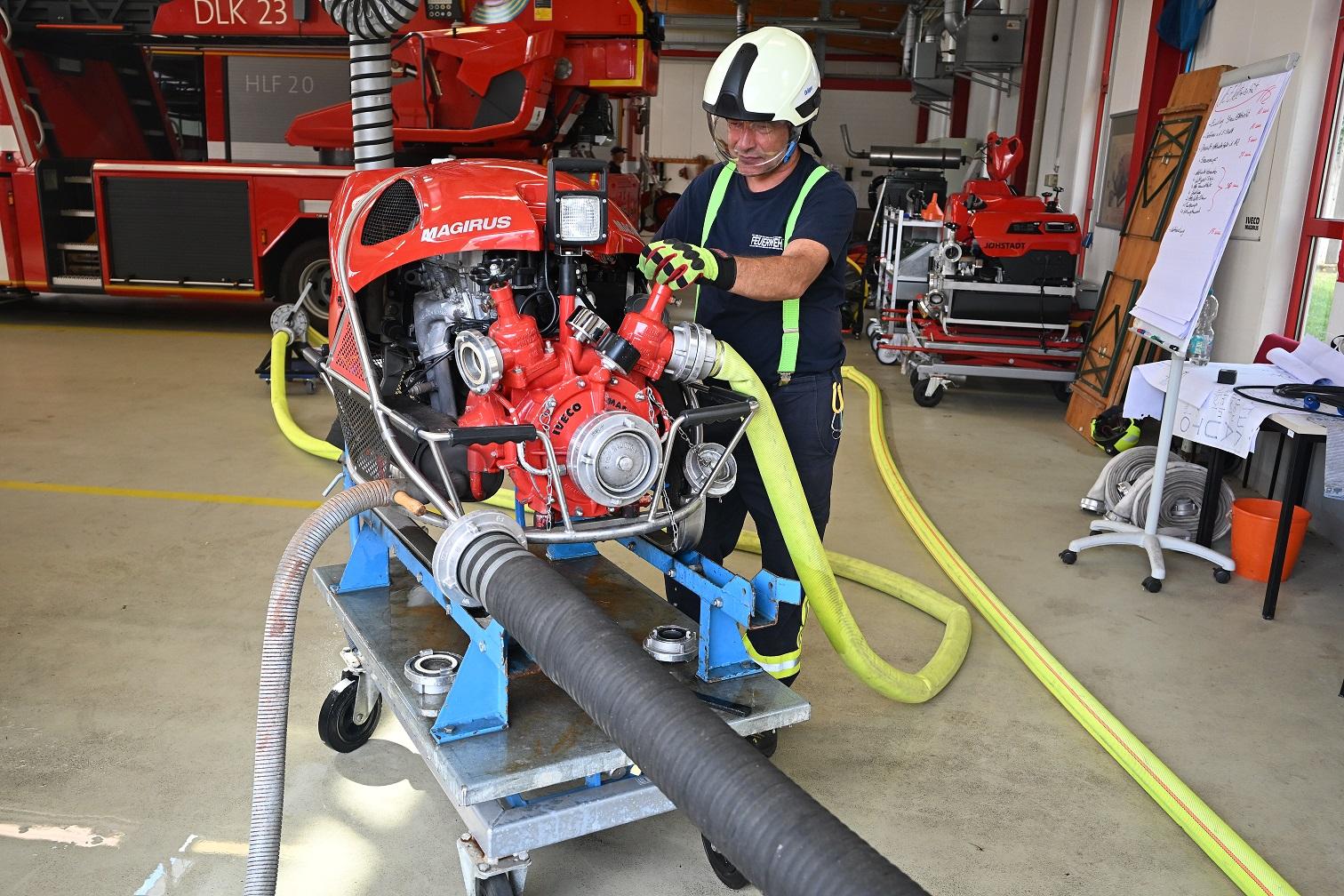 Feuerwehrmann steht an der Pumpe