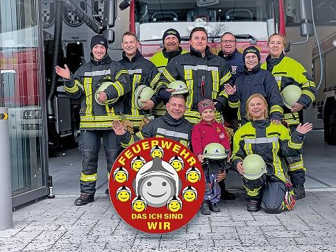 Feuerwehrmanschaft vor Feuerwehrauto